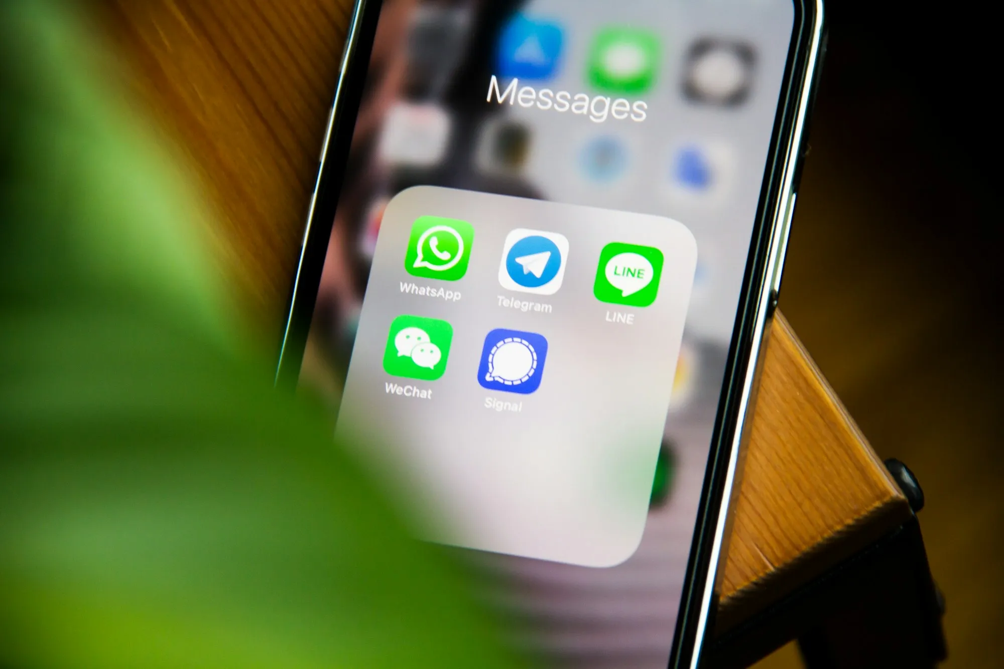 Celular mostrando a pasta de aplicativos de mensagens com o WhatsApp em destaque