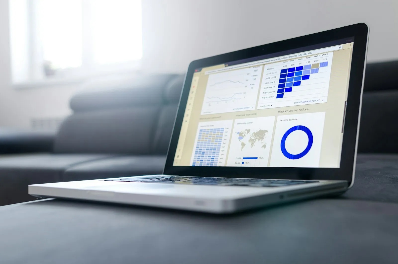 Notebook exibindo uma planilha com gráficos sobre um sofá