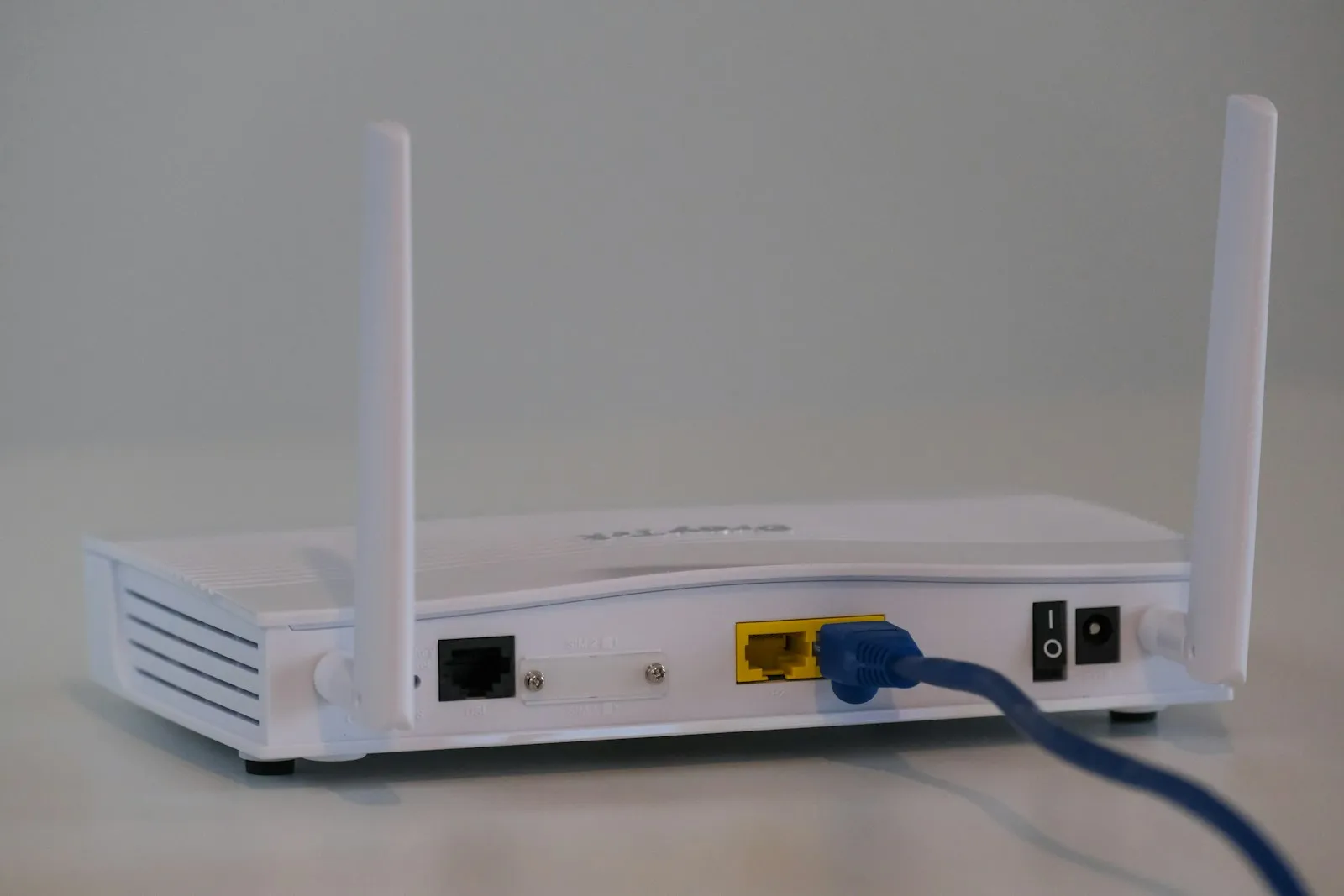 Roteador Wi-Fi branco com cabo de rede conectado