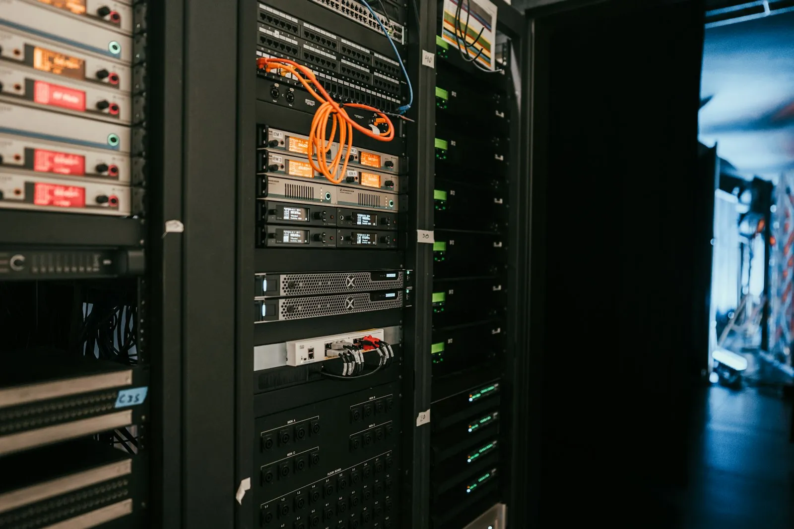 Rack de servidores e equipamentos de rede com cabos laranja