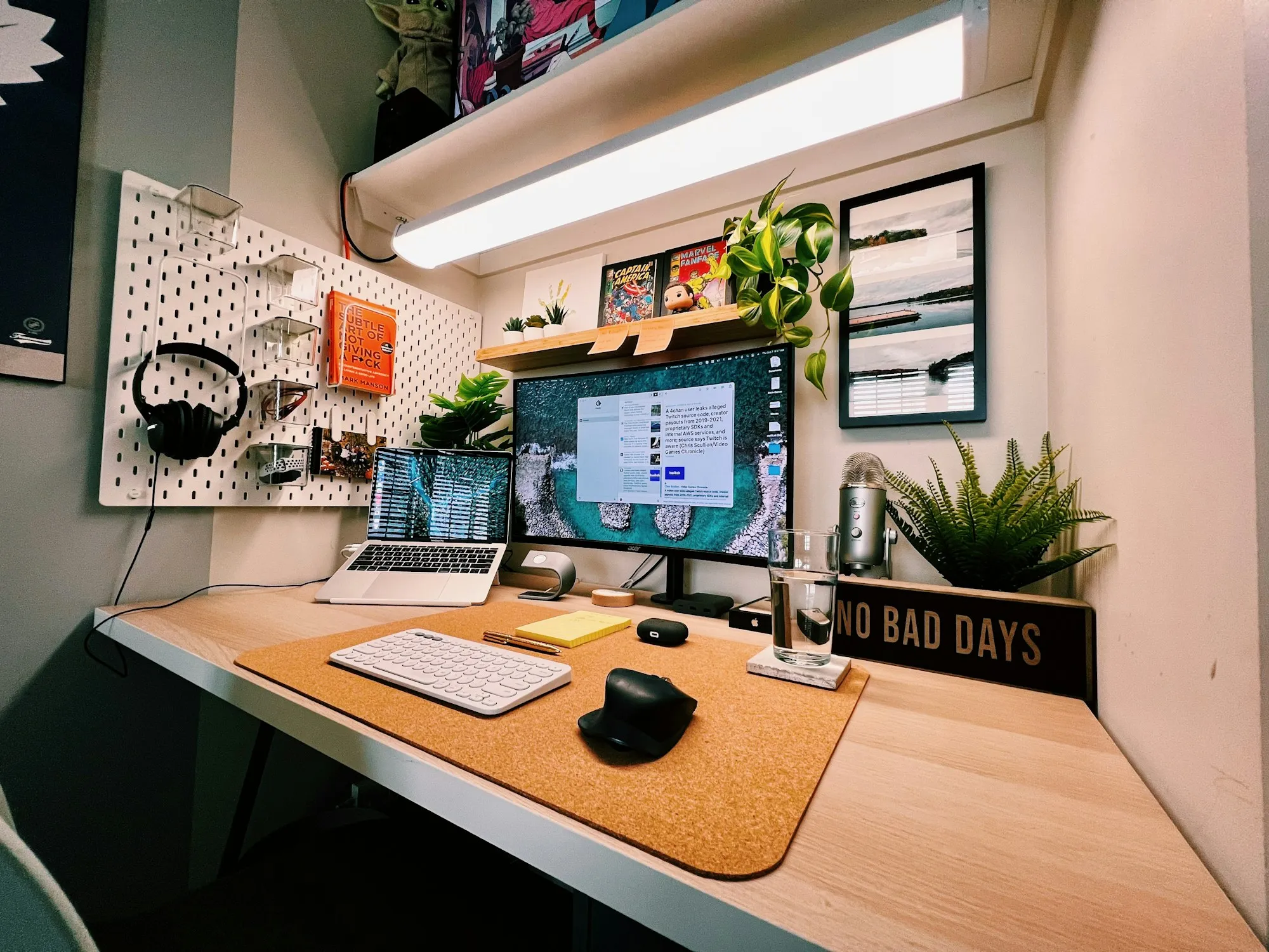 Mesa de trabalho organizada com notebook e monitor exibindo código