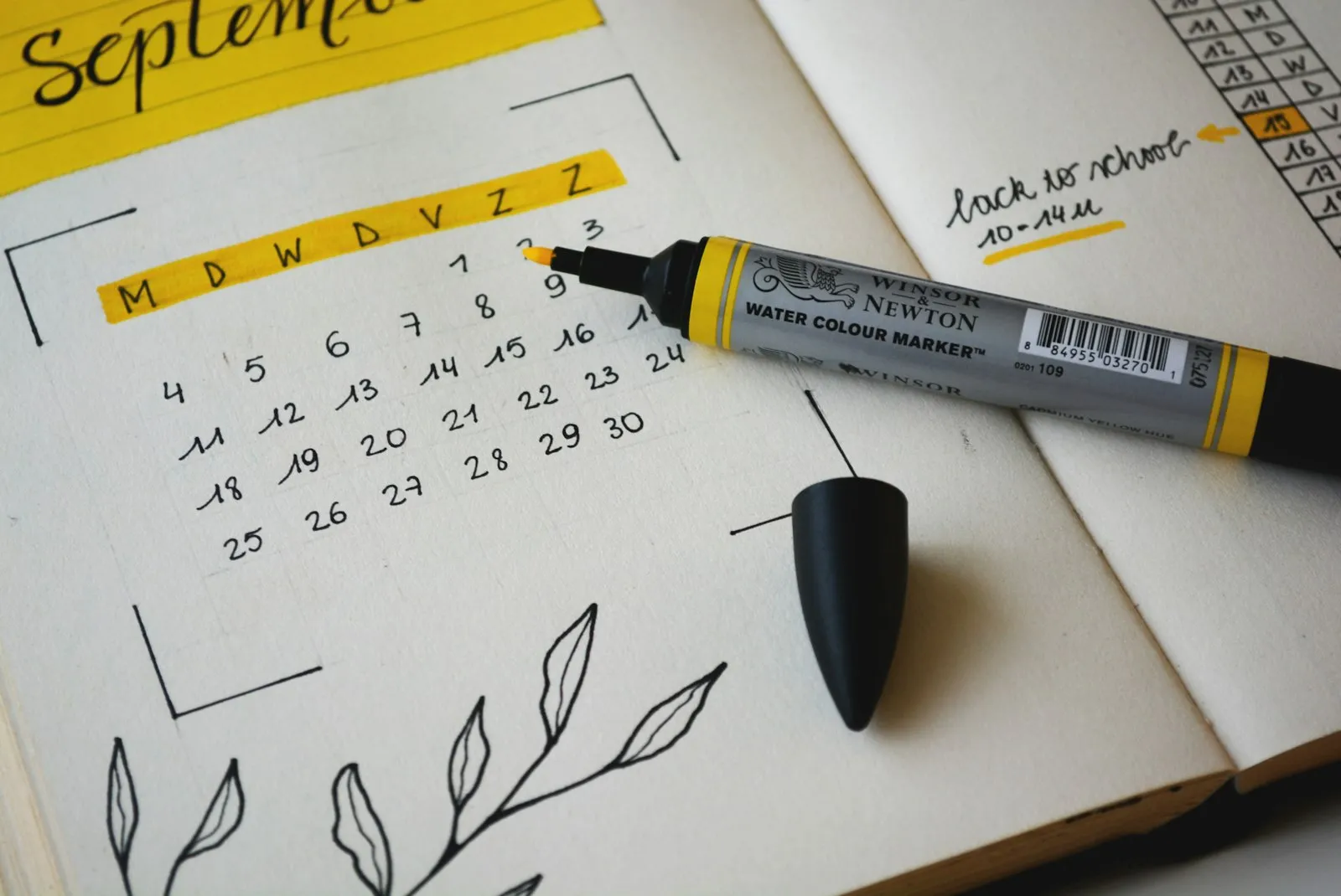 Agenda de papel aberta no mês de setembro com uma caneta marca-texto